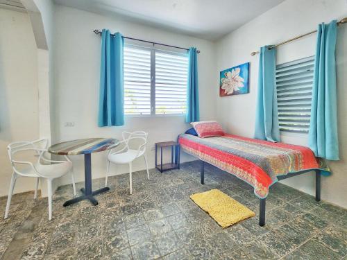 a bedroom with a bed and a table and chairs at Kokomo Hotel in Culebra