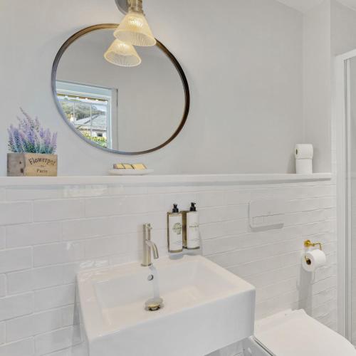 a white bathroom with a sink and a mirror at Admiral's House by Maison Pierre in Plymouth