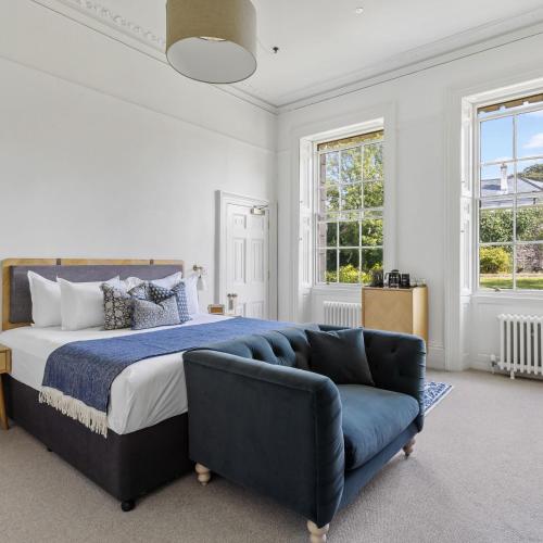 a bedroom with a bed and a blue couch at Admiral's House by Maison Pierre in Plymouth