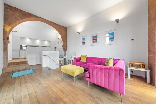 a living room with a pink couch and a yellow chair at Unique 1 Bedroom Near West End in Glasgow