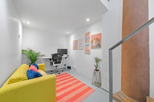 a living room with a yellow couch and a desk at Unique 1 Bedroom Near West End in Glasgow