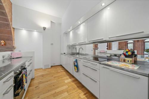 a large kitchen with white appliances and a wooden floor at Unique 1 Bedroom Near West End in Glasgow
