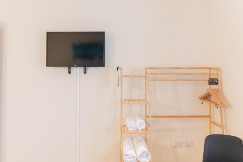 a flat screen tv hanging on a wall at Deangate Motel in Lydney