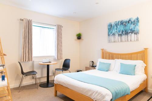 a bedroom with a bed and a table and chairs at Deangate Motel in Lydney