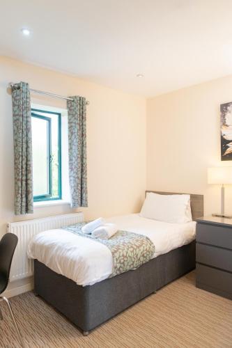 a bedroom with a bed and a window at Deangate Motel in Lydney