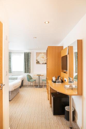 a hotel room with a bed and a desk in a room at Deangate Motel in Lydney