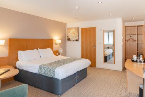 a hotel room with a bed and a desk at Deangate Motel in Lydney