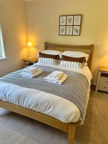 a bedroom with a large bed with two towels on it at Pendene in Hinton