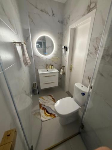 a white bathroom with a toilet and a sink at Haus Sonnenklang in Tihany