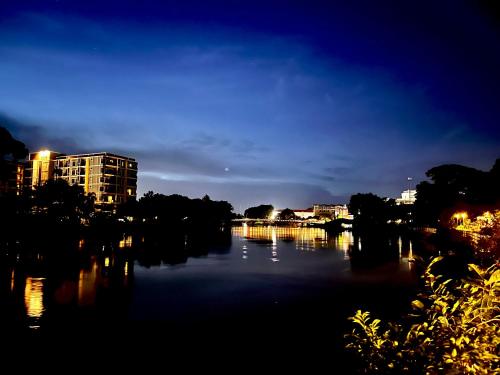 a view of a river at night with buildings at USABAI Riverside Boutique Hotel in Chanthaburi