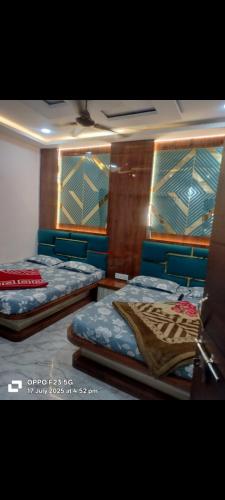 two twin beds in a room with blue sheets at Hotel shree shivay omkareshwar in Godarpura