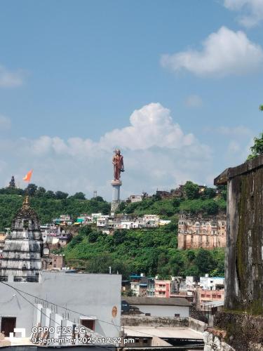 a view of a city with a statue on a hill at Hotel shree shivay omkareshwar in Godarpura