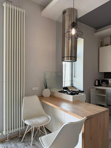 a kitchen with a counter and two white chairs at Kyiv Tokyo Apartment in Kyiv