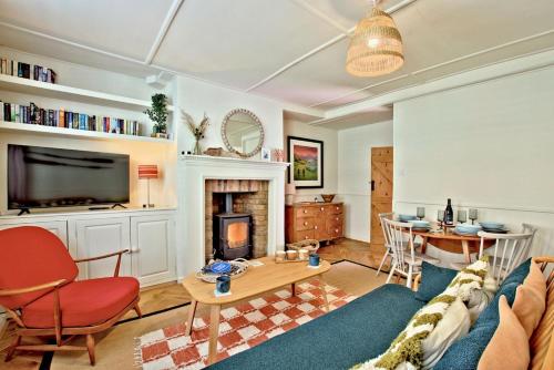 a living room with a couch and a table and a fireplace at Bluebell Cottage in Whitby