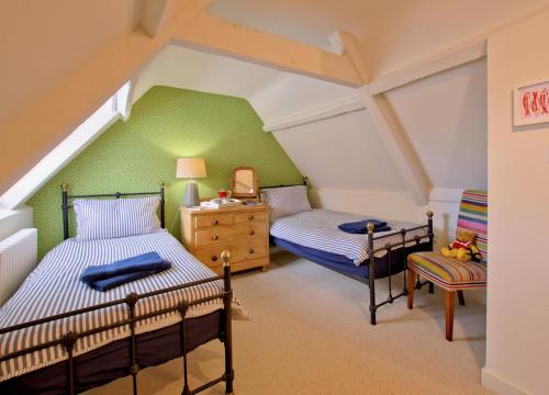 two beds in a room with a green wall at Bluebell Cottage in Whitby