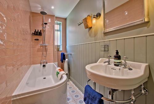a bathroom with a sink and a tub next to a toilet at Bluebell Cottage in Whitby