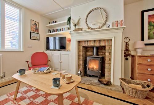 a living room with a fireplace and a table at Bluebell Cottage in Whitby