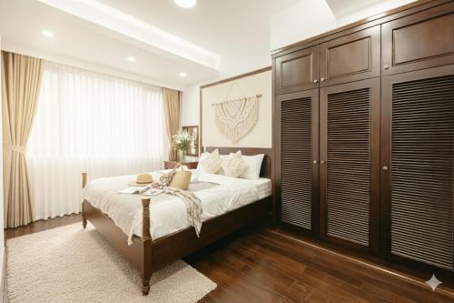 a bedroom with a bed and a large window at Lunaria Two Bedroom Apartment - The Epicenter of Luxury and Convenience in Hanoi
