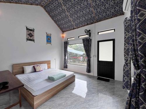 a bedroom with a bed and a large window at Ume Homestay in Mai Châu