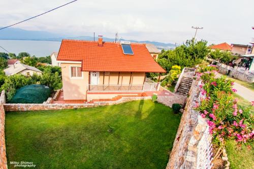 a house with an orange roof and a green yard at Vila Oaza in Star Dojran