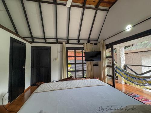 a bedroom with a bed and a large window at Hostal Antawara Tayrona in El Zaino