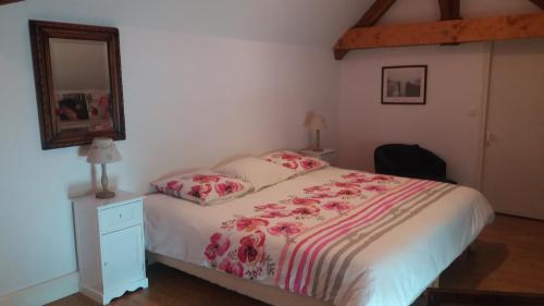 1 dormitorio con 1 cama con tocador y espejo en Cottage 2 personnes, en Lormes