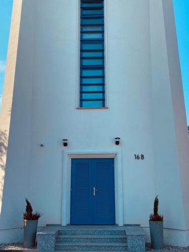 a lighthouse with a blue door in front of it at Wieża Ciśnień in Głuchołazy