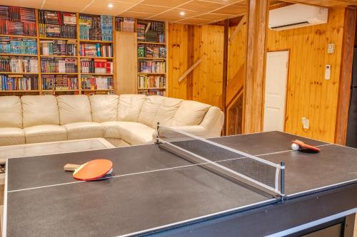 a ping pong table in a living room with a couch at Stunning! Pocono Escape! HotTub Sauna Pool Ski Pet-Friendly Firepit Game Room Fireplace BBQ Lakes Tennis Fishing in Long Pond