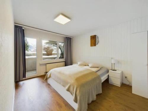 a bedroom with a large bed and a window at Alpine Retreat 4 Person Apartment near Zermatt with parking! in Täsch