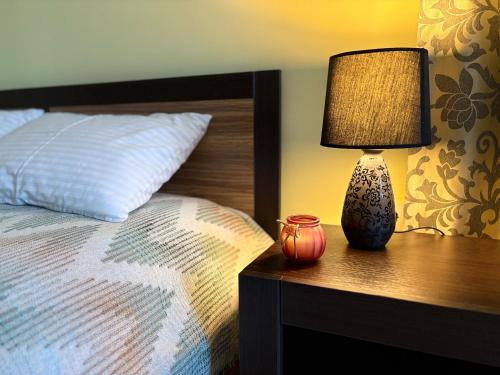 a lamp on a night stand next to a bed at VerhHouse in Yaremche