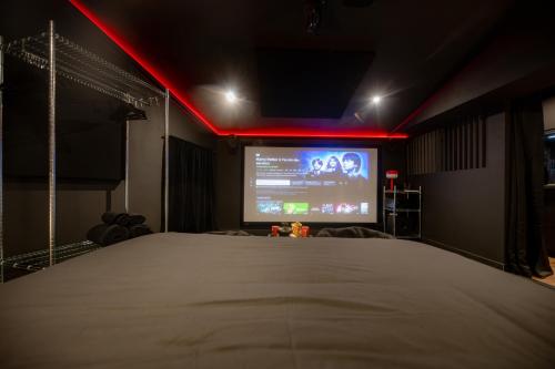 a room with a bed and a projection screen at INFINITY I Seventharts I Cinema room in Angoulême