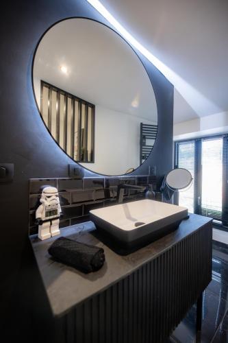 a bathroom with a large mirror and a sink at Infinityroom I Seventharts I Cinema room in Angoulême