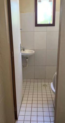 a small bathroom with a sink and a toilet at Chalé - Praia in Ubatuba