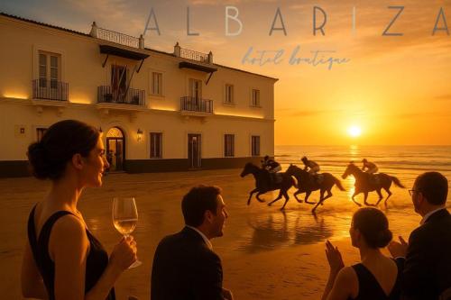 a group of people watching horses on the beach at sunset at Albariza Hotel Boutique in Sanlúcar de Barrameda