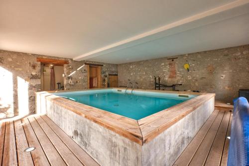 a large pool in a room with a wooden floor at Maison Dans Ancienne Forge in Noyarey