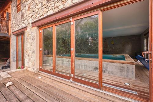 a wooden deck with a swimming pool inside of a house at Maison Dans Ancienne Forge in Noyarey