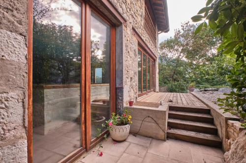 a glass door of a building with a potted plant at Maison Dans Ancienne Forge in Noyarey