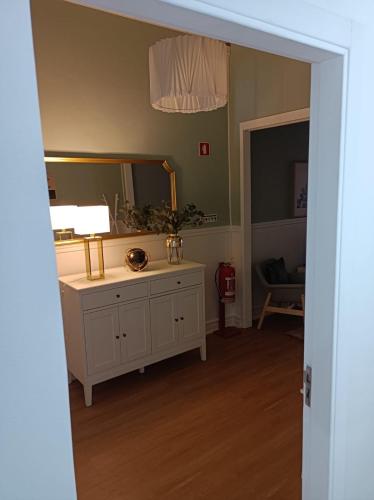 a bathroom with a mirror and a dresser at Cantinho da Cruz in Ponta Delgada