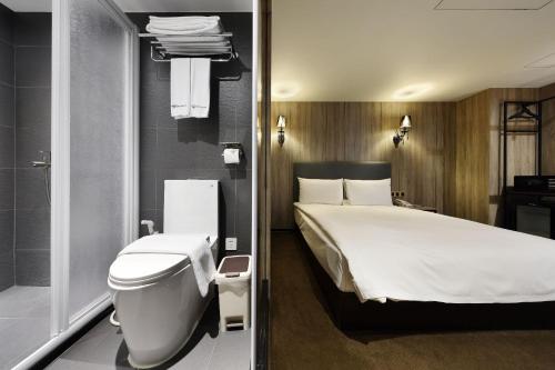 a hotel room with a bed and a toilet at Airline Inn Ximen in Taipei
