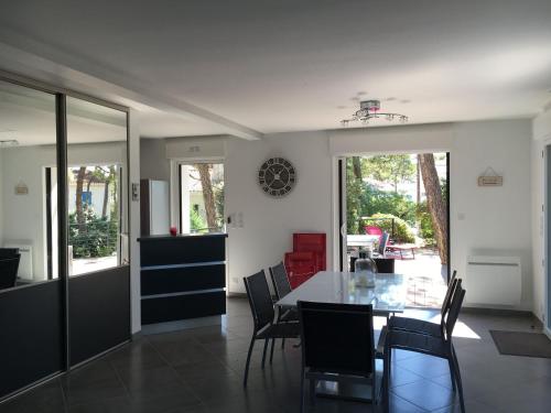 a dining room with a table and chairs at Maison La tranche-sur-mer sous les pins in La Tranche-sur-Mer