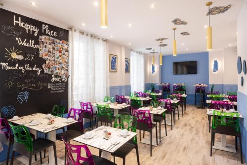 a dining room with tables and chairs and a chalkboard at Hôtel Byakko Nice in Nice