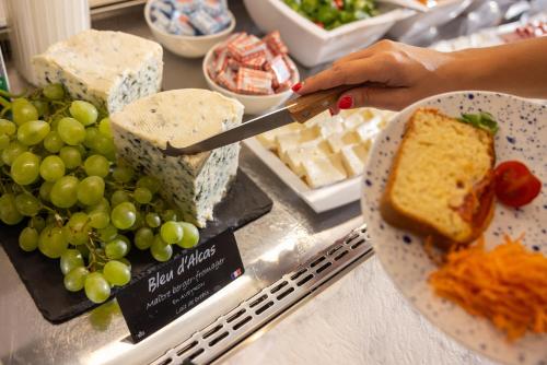 a person cutting a piece of bread with a knife at Hôtel Byakko Nice in Nice