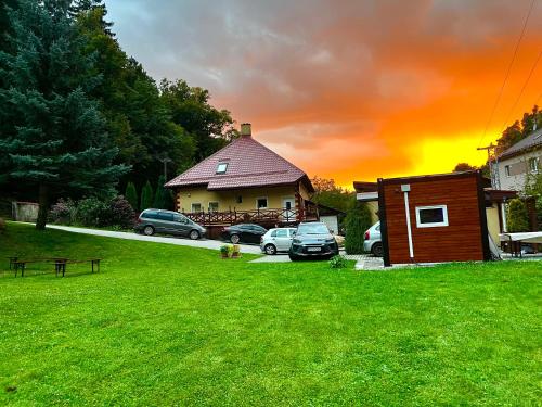 a house with cars parked in front of a yard at Privát Adriana in Kremnica