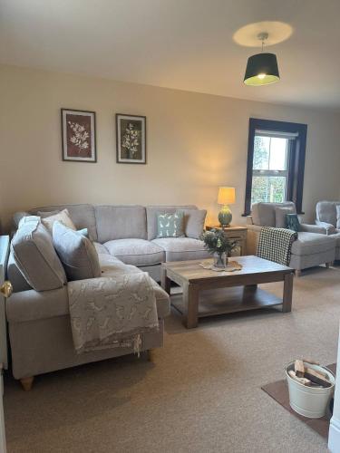 a living room with a couch and a table at Waterditch Farmhouse in Winkton