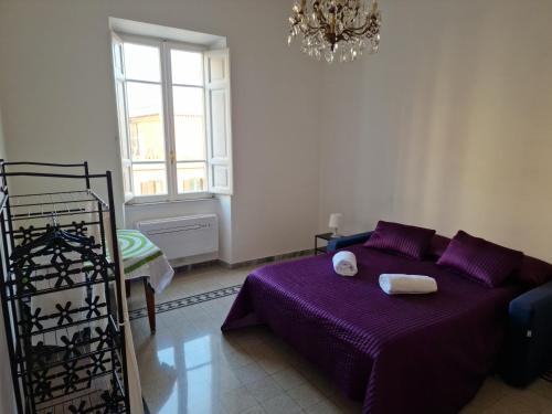 a bedroom with a purple bed and a chandelier at Delizioso appartamento al Pigneto in Rome