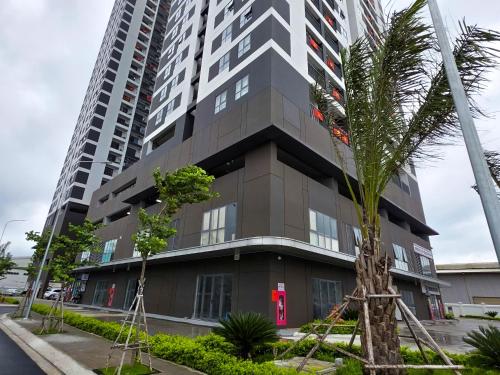 a tall building with a palm tree in front of it at New Lavida in Dĩ An