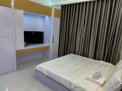 a bedroom with a bed and a window with a television at New Lavida in Dĩ An