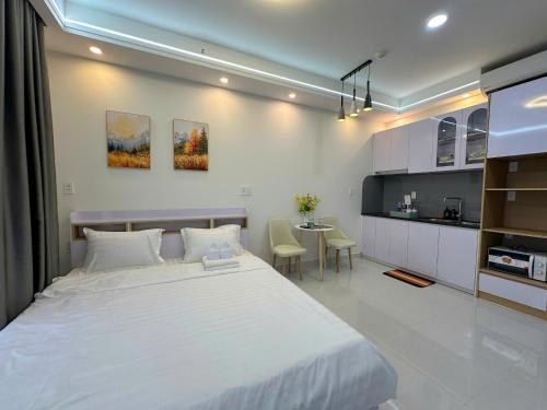 a bedroom with a large white bed and a table at New Lavida in Dĩ An