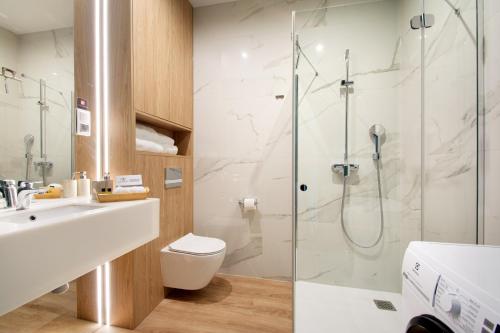 ein Badezimmer mit Dusche, Toilette und Waschbecken in der Unterkunft NORTH Apartments, Vibe Ustka in Ustka