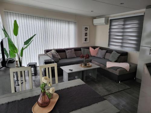 a living room with a couch and a table at Huis Frieda am See, Nähe Arnheim in Lathum